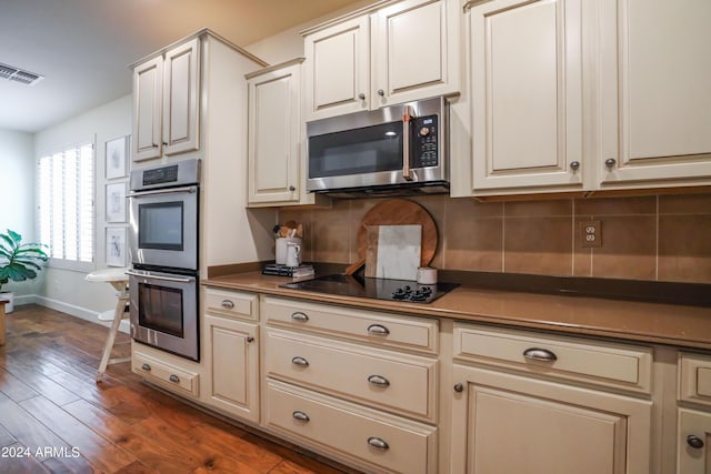 kitchen with tasteful backsplash, stainless steel appliances, and dark wood-type flooring