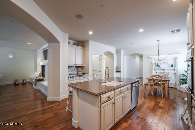 kitchen with pendant lighting, sink, a kitchen breakfast bar, an island with sink, and stainless steel dishwasher