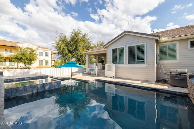 view of pool with a grill and a patio