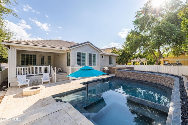 view of pool with an in ground hot tub, area for grilling, a patio area, and a fire pit