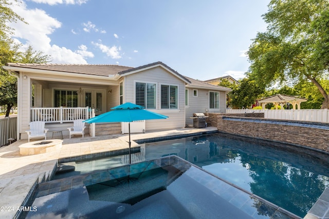 view of pool featuring an in ground hot tub, area for grilling, an outdoor fire pit, and a patio area