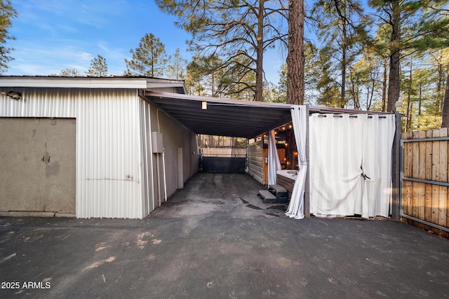 view of car parking featuring a carport and fence