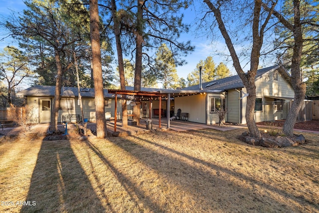 rear view of house featuring a patio area and fence