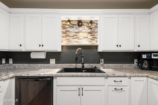 kitchen featuring a sink, stainless steel dishwasher, and white cabinetry