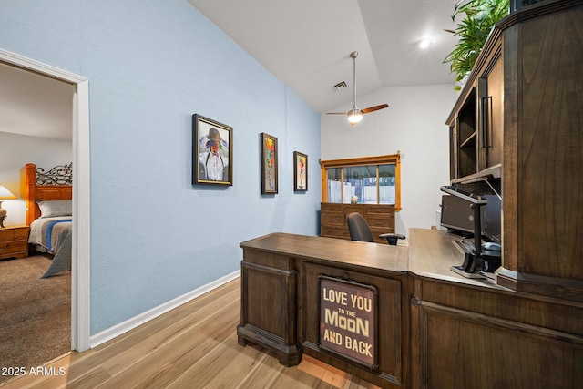 office area featuring visible vents, a ceiling fan, light wood finished floors, baseboards, and vaulted ceiling