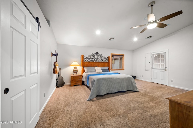 bedroom featuring visible vents, lofted ceiling, a barn door, and carpet floors