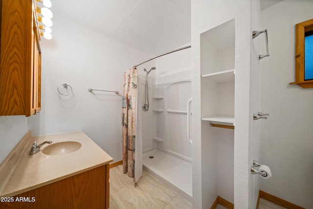 bathroom featuring curtained shower, vanity, and baseboards