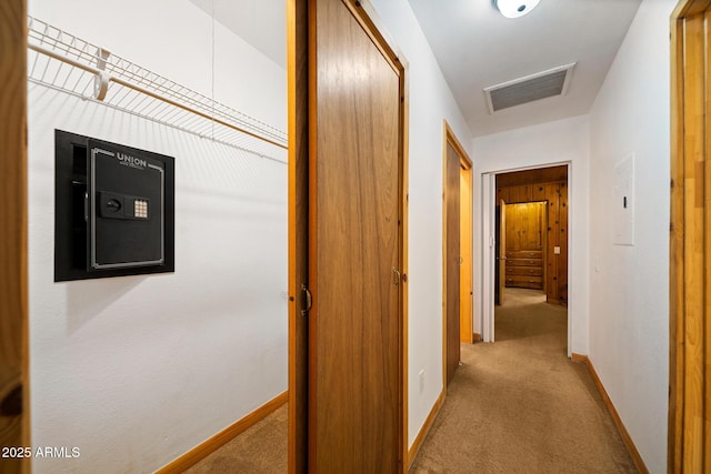 hall with carpet flooring, baseboards, and visible vents