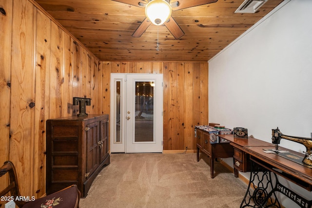 home office featuring visible vents, light carpet, wooden walls, wooden ceiling, and ceiling fan