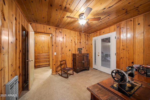 interior space featuring wood walls, wooden ceiling, ceiling fan, and carpet floors