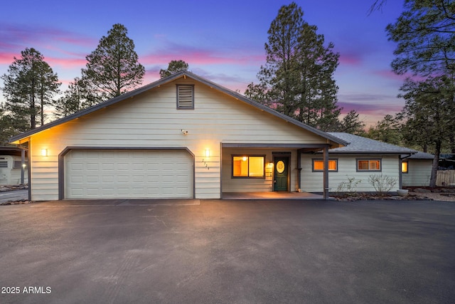 view of front of house with aphalt driveway, roof with shingles, and an attached garage