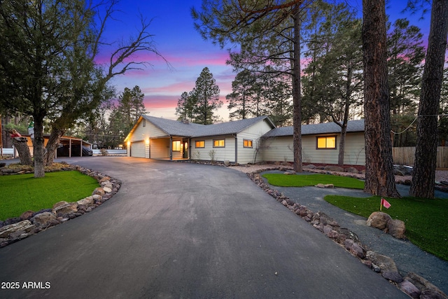 view of front of home with driveway, an attached garage, and a yard