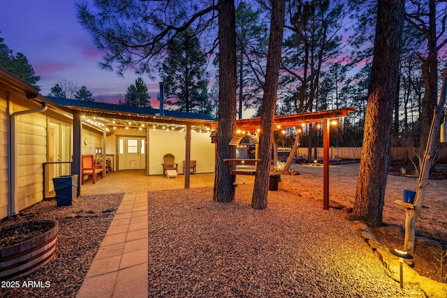 yard at dusk with a patio and fence