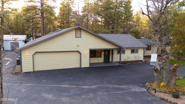 ranch-style home with an attached garage, central AC, and driveway