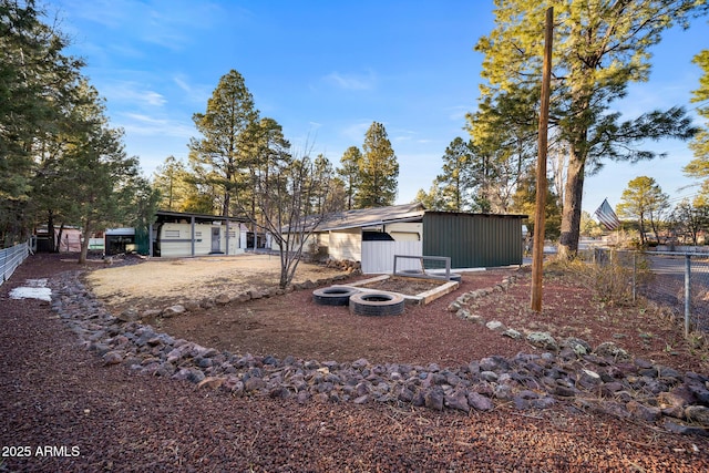 back of property with an outdoor structure, fence, and a pole building