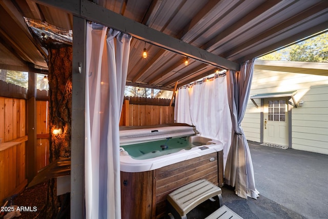 view of patio / terrace featuring a hot tub and fence