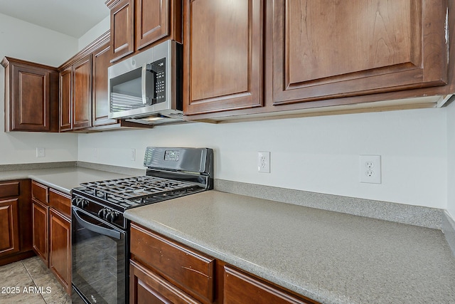 kitchen featuring light countertops, gas stove, and stainless steel microwave
