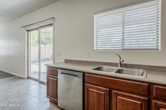 kitchen featuring stainless steel dishwasher, light tile patterned flooring, and a sink