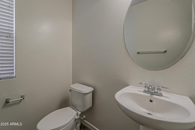 half bathroom featuring a sink and toilet
