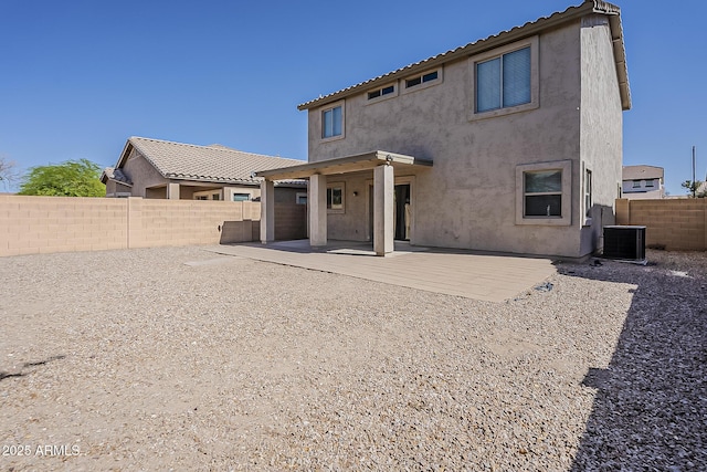 rear view of house with cooling unit, stucco siding, a fenced backyard, and a patio