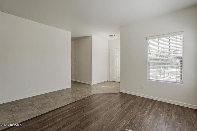 empty room featuring wood finished floors and baseboards