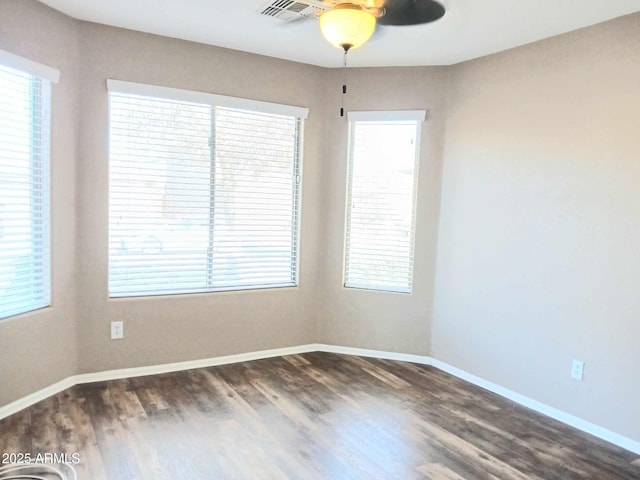 unfurnished room featuring ceiling fan, dark hardwood / wood-style flooring, and a healthy amount of sunlight