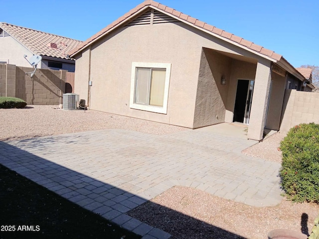 back of house with central air condition unit and a patio