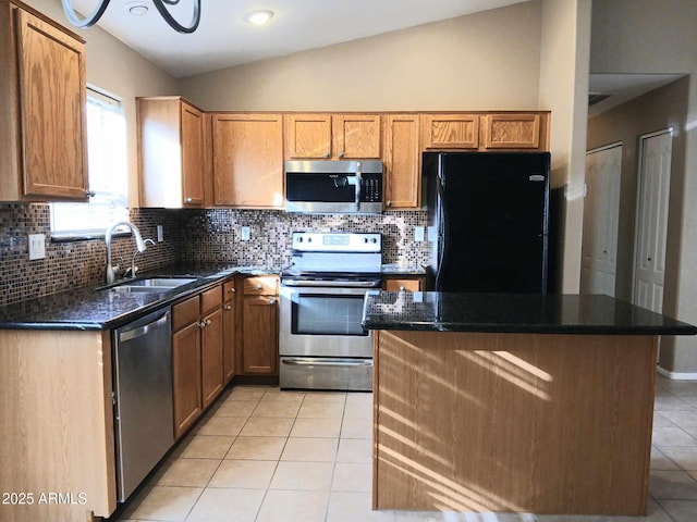 kitchen with a center island, sink, vaulted ceiling, appliances with stainless steel finishes, and light tile patterned flooring