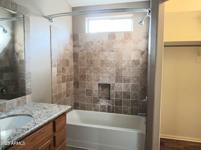 bathroom featuring vanity and tiled shower / bath