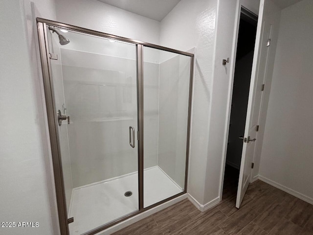 bathroom featuring hardwood / wood-style flooring and a shower with shower door