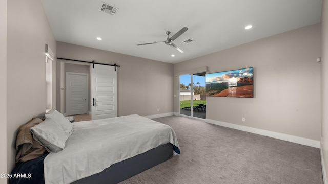 carpeted bedroom featuring ceiling fan and a barn door