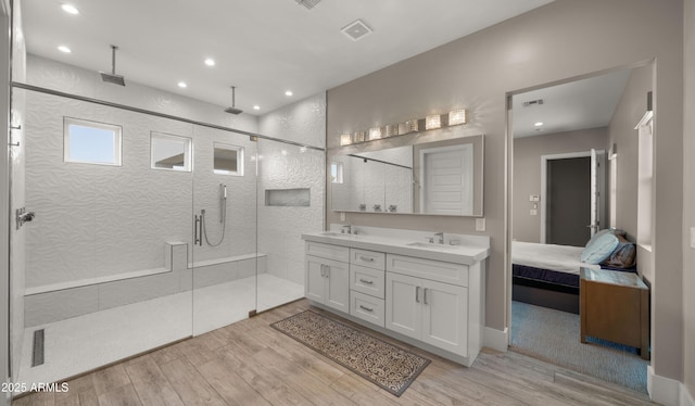 bathroom with wood-type flooring, walk in shower, and vanity