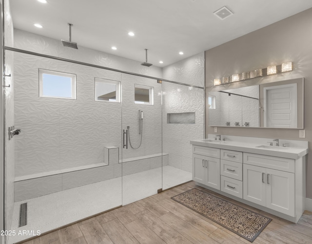 bathroom with wood-type flooring, an enclosed shower, and vanity