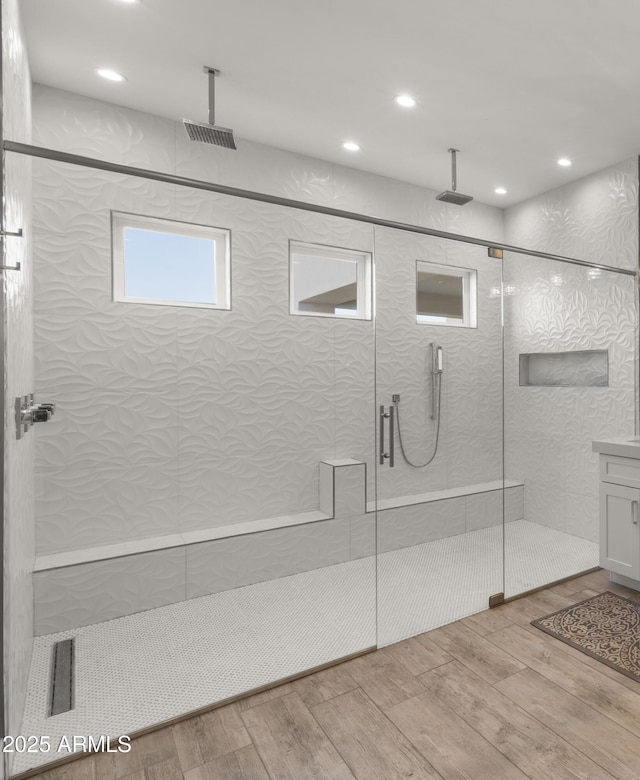 bathroom with wood-type flooring and an enclosed shower