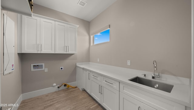 clothes washing area featuring cabinets, hookup for a gas dryer, washer hookup, sink, and hookup for an electric dryer