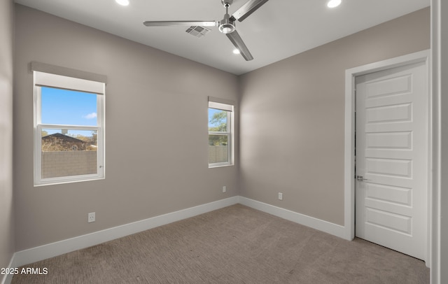 carpeted spare room featuring ceiling fan