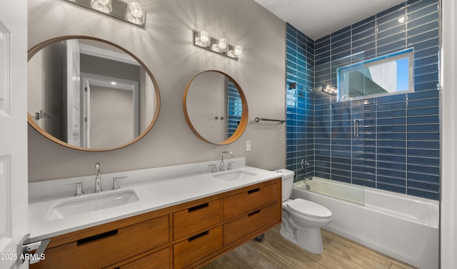 full bathroom with wood-type flooring, combined bath / shower with glass door, vanity, and toilet