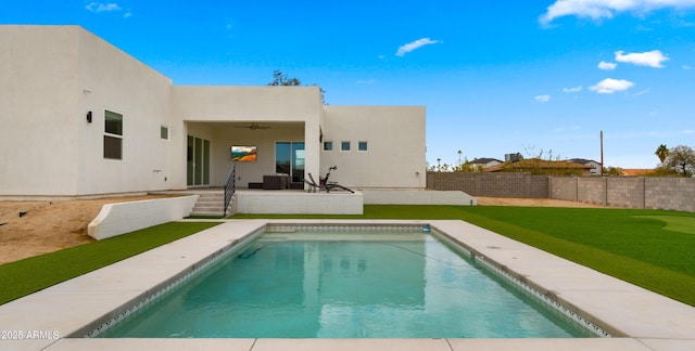 rear view of property featuring ceiling fan, a fenced in pool, a yard, and a patio