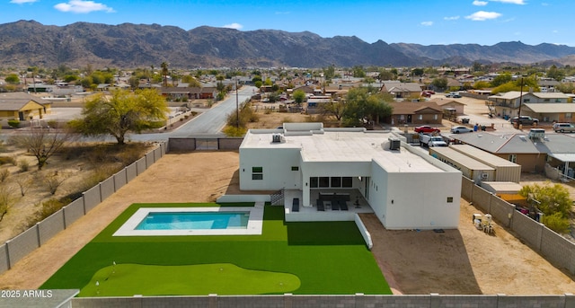 exterior space with a fenced in pool, a mountain view, and a patio