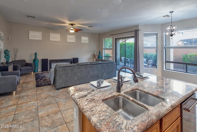 7252 E Nance St, Mesa, AZ 85207 - kitchen with open floor plan, a ceiling fan, brown cabinets, light stone countertops, and decorative light fixtures
