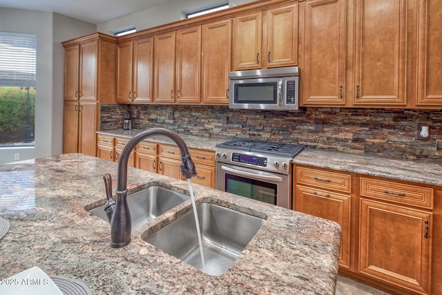 7252 E Nance St, Mesa, AZ 85207 - kitchen with stainless steel appliances, light stone counters, tasteful backsplash, and brown cabinetry