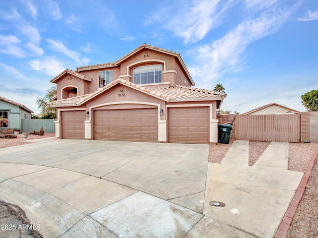 mediterranean / spanish house featuring concrete driveway, a tiled roof, an attached garage, fence, and stucco siding