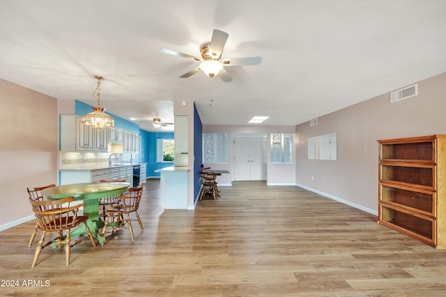 dining room with light wood-type flooring, visible vents, baseboards, and beverage cooler