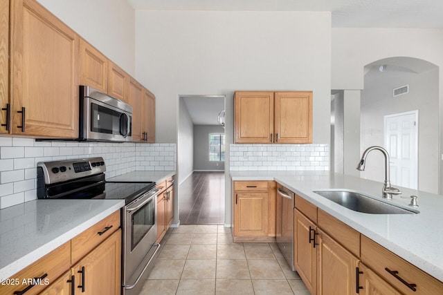 3002 S Marigold Pl, Chandler, AZ 85248 - kitchen featuring a sink, stainless steel appliances, light tile patterned flooring, visible vents, and arched walkways