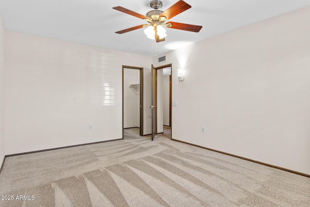 empty room with ceiling fan, visible vents, light carpet, and baseboards