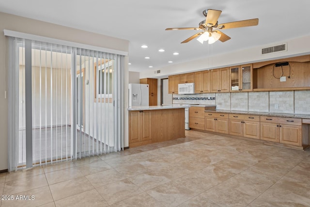 kitchen with white appliances, a ceiling fan, backsplash, visible vents, and glass insert cabinets