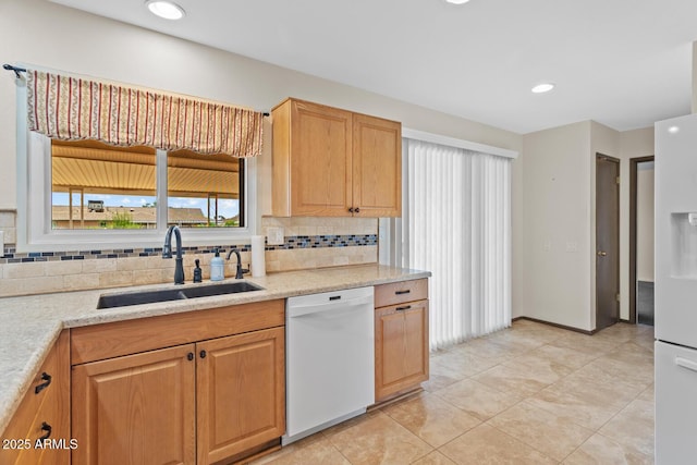 kitchen with a sink, light tile patterned floors, white appliances, and tasteful backsplash