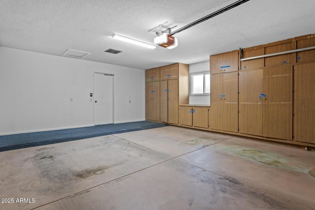 garage with baseboards, visible vents, and a garage door opener