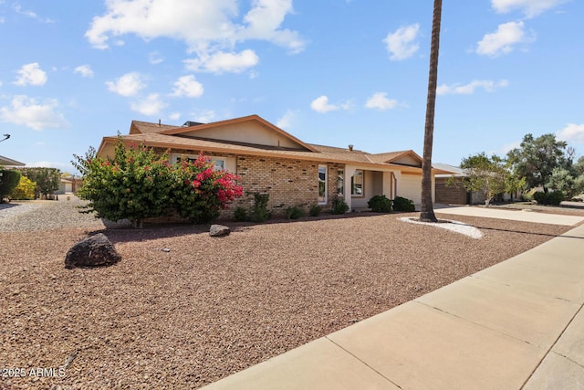 ranch-style home with an attached garage, driveway, and brick siding