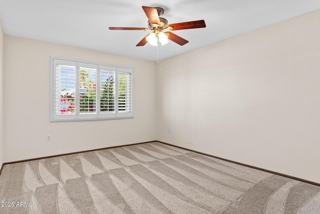 spare room with baseboards, ceiling fan, and light carpet